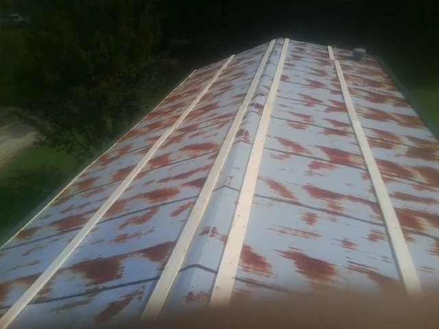 Rusted metal roof panels with new wood purlins before replacement — Storm Damage Roof Repair in Lumber Bridge by Roofing Brothers
