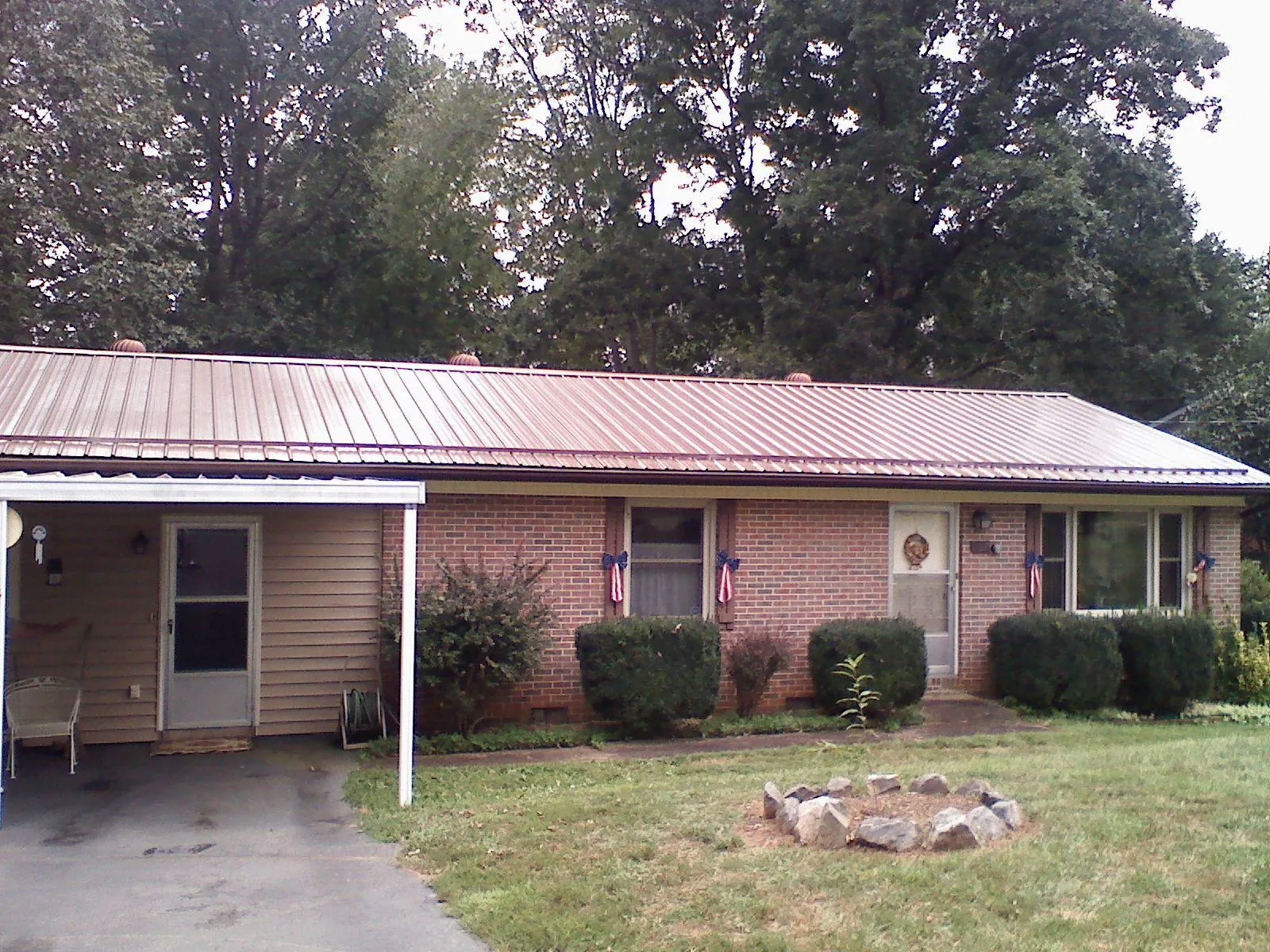 Bronze metal roof and carport on a brick ranch home — Roof Repair work by our crew in Lumber Bridge