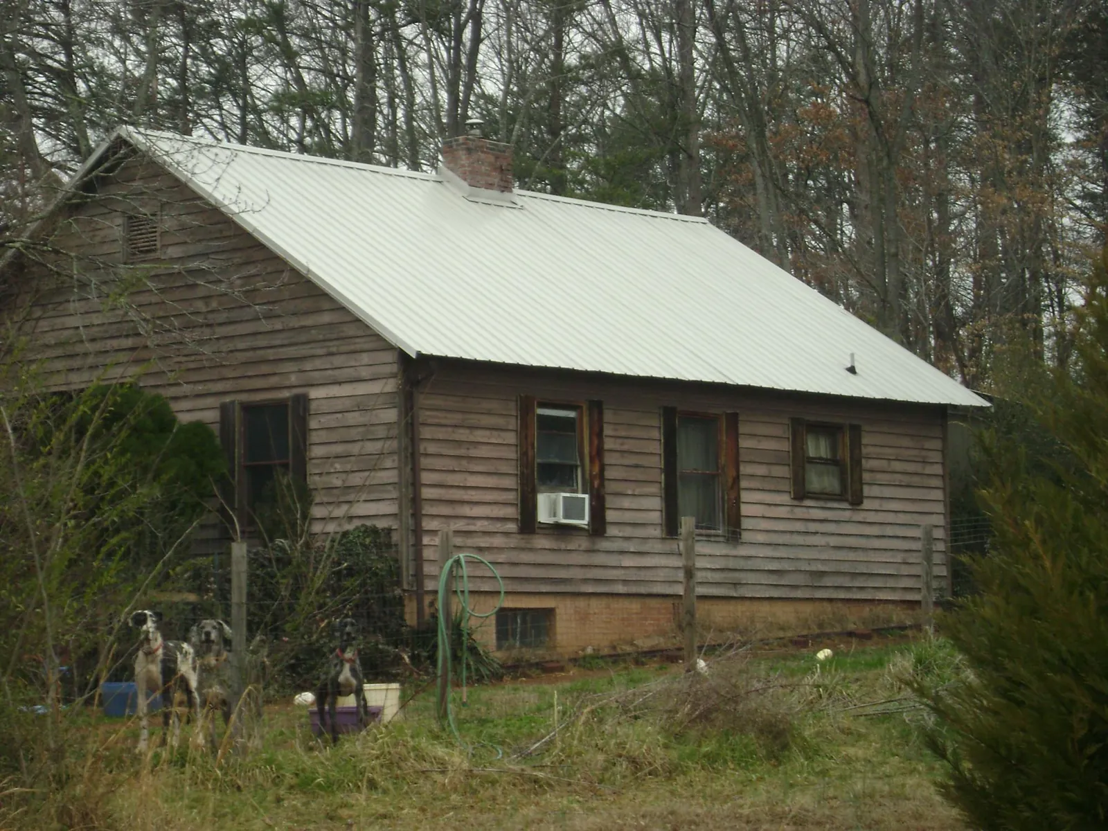 White metal roof on an old wood sided farmhouse, from a Metal Roof Installation job in Lumber Bridge